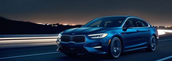 Blue sedan driving at night