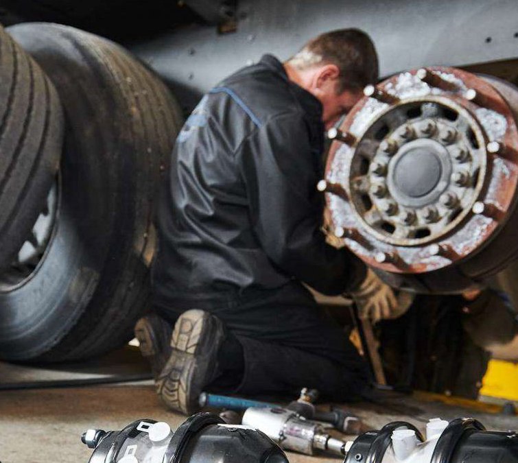 Technician servicing a truck wheel hub
